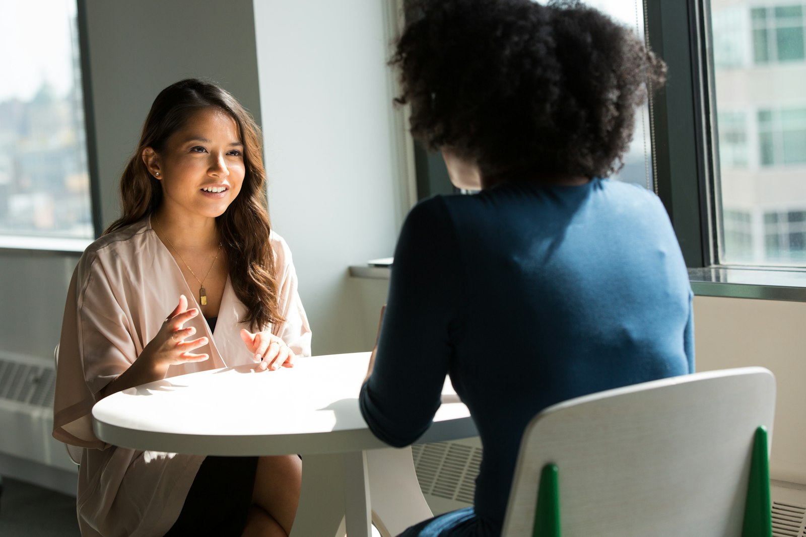 Duas colegas em uma conversa de feedback próxima e genuína