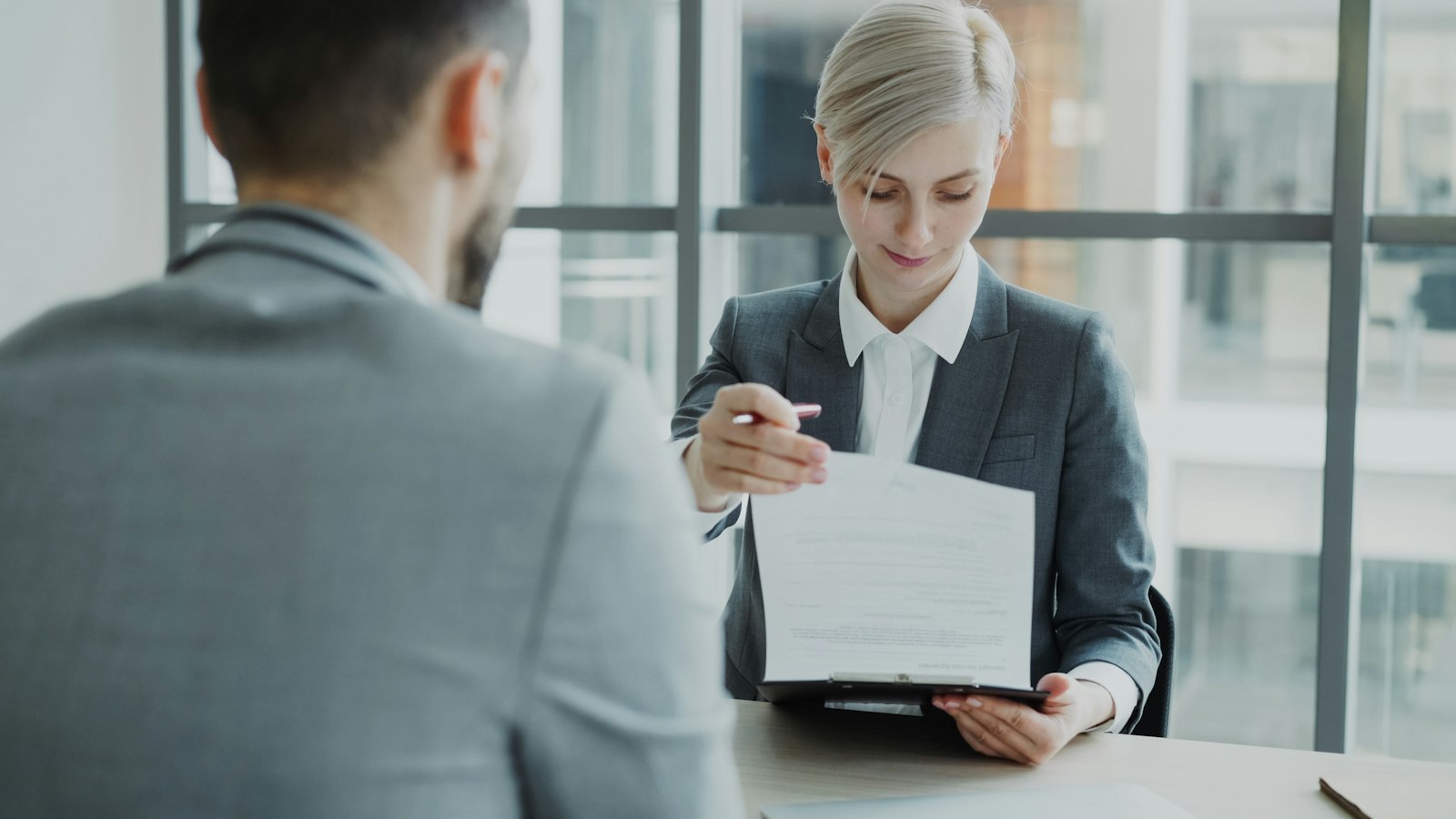 RH entregando o checklist de documentos de admissão para o novo colaborador revisar e assinar